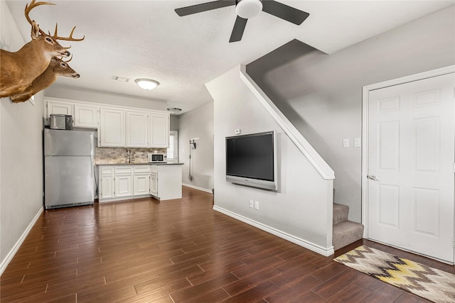 2205 Erin Glen Ct, Deer Park, TX 77536 - unfurnished living room featuring stairs, a ceiling fan, baseboards, and dark wood-style flooring
