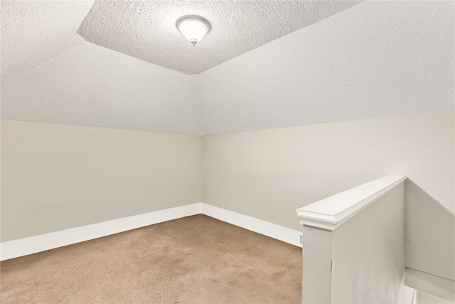 2205 Erin Glen Ct, Deer Park, TX 77536 - bonus room with carpet floors, vaulted ceiling, a textured ceiling, and baseboards