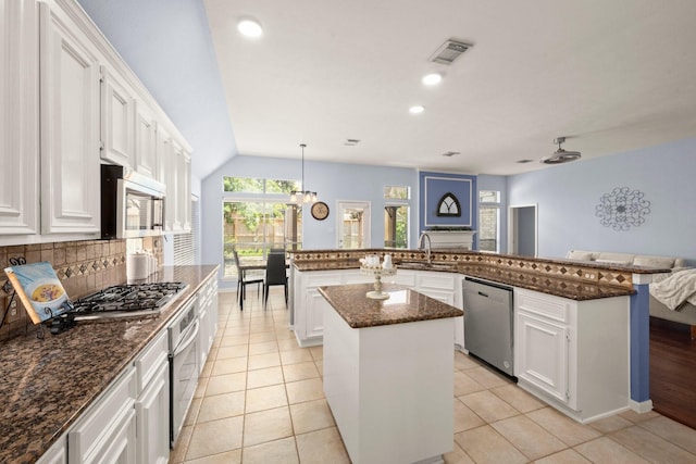 11722 Gray Forest Trl, Tomball, TX 77377 - kitchen with appliances with stainless steel finishes, a center island, a sink, tasteful backsplash, and white cabinets