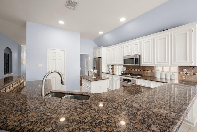 11722 Gray Forest Trl, Tomball, TX 77377 - kitchen featuring appliances with stainless steel finishes, a sink, a center island, decorative backsplash, and vaulted ceiling