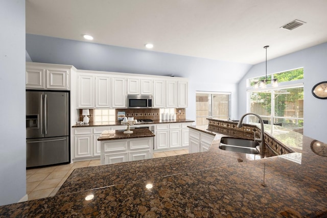 11722 Gray Forest Trl, Tomball, TX 77377 - kitchen with stainless steel appliances, a sink, a center island with sink, lofted ceiling, and tasteful backsplash