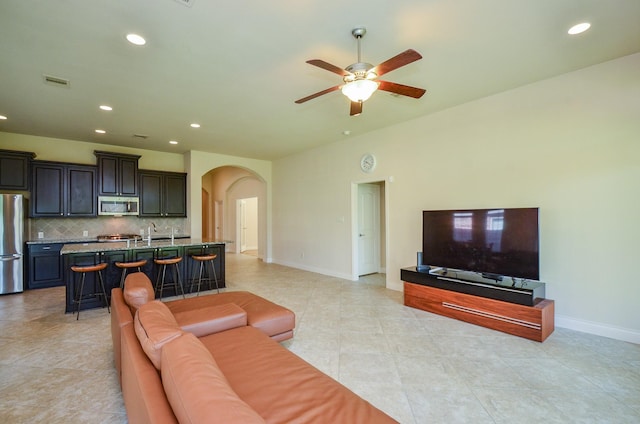 13806 Crystal Harbor Ln, Pearland, TX 77584 - living room featuring arched walkways, a ceiling fan, recessed lighting, baseboards, and light tile patterned flooring