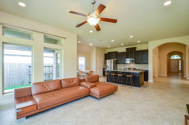 13806 Crystal Harbor Ln, Pearland, TX 77584 - living room featuring arched walkways, light tile patterned floors, ceiling fan, and recessed lighting
