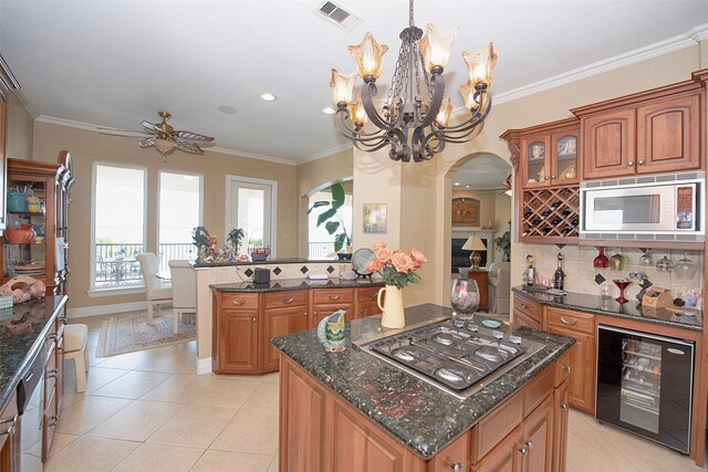 2242 Marina Way, League City, TX 77565 - kitchen featuring beverage cooler, appliances with stainless steel finishes, arched walkways, brown cabinets, and ornamental molding