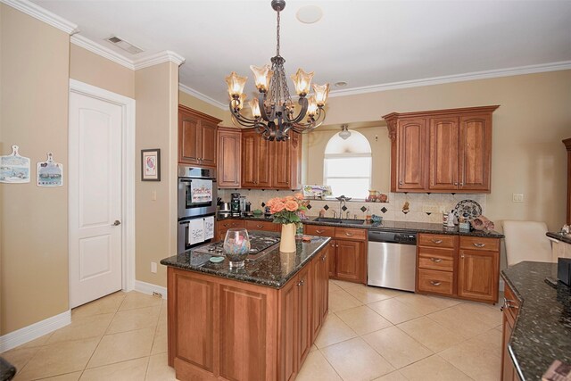 2242 Marina Way, League City, TX 77565 - kitchen with appliances with stainless steel finishes, a chandelier, light tile patterned floors, decorative backsplash, and brown cabinetry