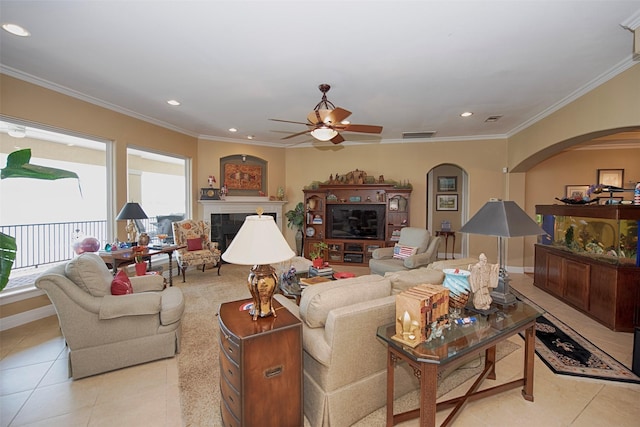 2242 Marina Way, League City, TX 77565 - tiled living room with arched walkways, a ceiling fan, a fireplace, recessed lighting, and crown molding