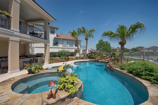 2242 Marina Way, League City, TX 77565 - view of pool with an outdoor kitchen, a pool with connected hot tub, a ceiling fan, a water view, and a patio area