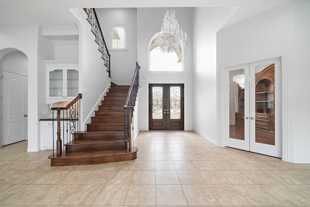 169 Westlake Pt, Montgomery, TX 77356 - foyer entrance featuring french doors, stairway, a towering ceiling, light tile patterned floors, and arched walkways