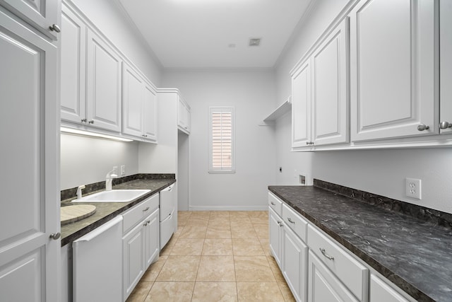 169 Westlake Pt, Montgomery, TX 77356 - laundry area featuring cabinet space, ornamental molding, hookup for an electric dryer, hookup for a washing machine, and light tile patterned floors