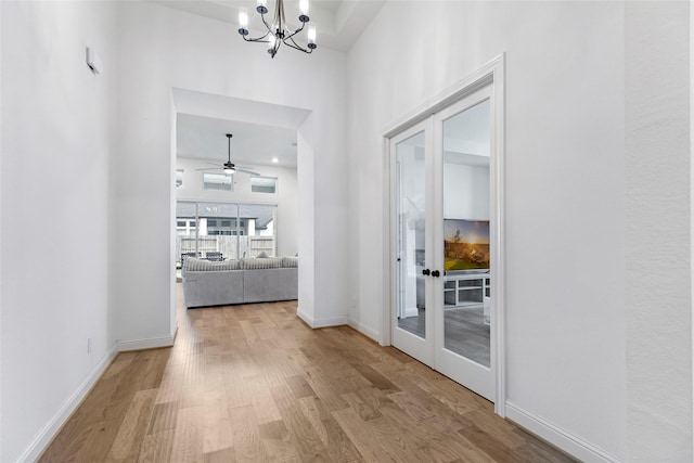 11914 Parsifal Creek Rd, Humble, TX 77346 - hallway with wood finished floors, a chandelier, baseboards, a towering ceiling, and french doors