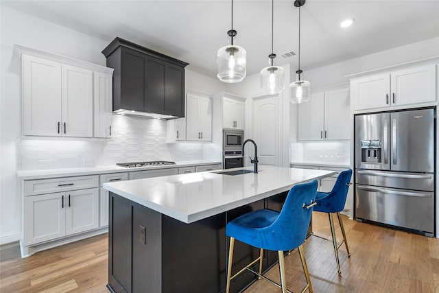 11914 Parsifal Creek Rd, Humble, TX 77346 - kitchen with appliances with stainless steel finishes, a sink, tasteful backsplash, light wood-style flooring, and light countertops