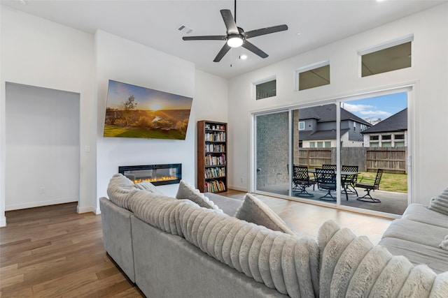 11914 Parsifal Creek Rd, Humble, TX 77346 - living room featuring ceiling fan, a glass covered fireplace, wood finished floors, recessed lighting, and baseboards