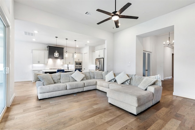 11914 Parsifal Creek Rd, Humble, TX 77346 - living room featuring light wood finished floors, a ceiling fan, a chandelier, recessed lighting, and baseboards