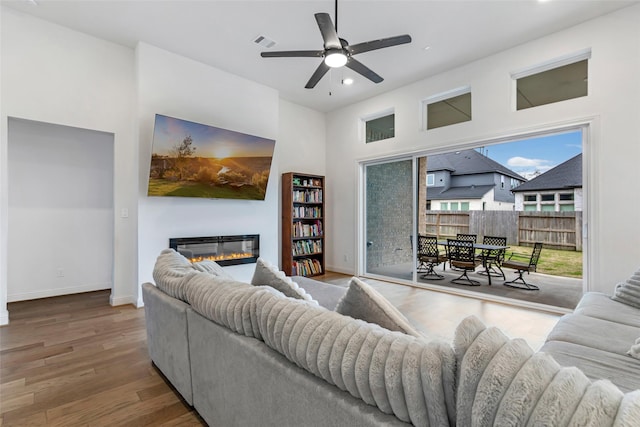 11914 Parsifal Creek Rd, Humble, TX 77346 - living area with a glass covered fireplace, ceiling fan, recessed lighting, wood finished floors, and baseboards