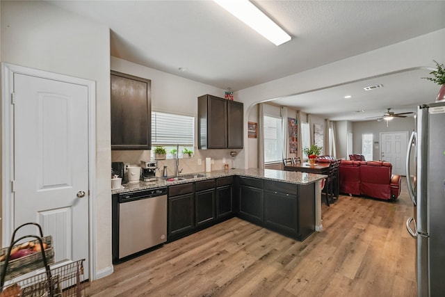 23659 Goodfellow Dr, Spring, TX 77373 - kitchen with appliances with stainless steel finishes, a sink, light wood finished floors, light stone counters, and recessed lighting