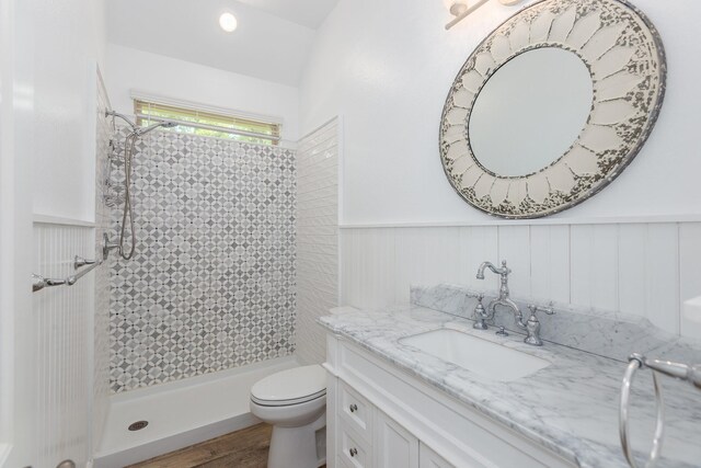 19276 Yellow Chestnut Ln, New Caney, TX 77357 - bathroom featuring vanity, tiled shower, toilet, wainscoting, and wood finished floors