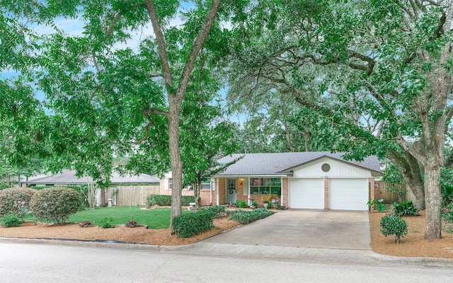 1103 Hillcrest Dr, Conroe, TX 77301 - view of front facade featuring an attached garage, concrete driveway, brick siding, and roof with shingles