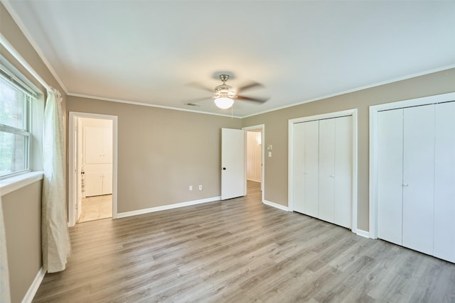 1103 Hillcrest Dr, Conroe, TX 77301 - unfurnished bedroom with multiple closets, light wood-type flooring, baseboards, ornamental molding, and a ceiling fan
