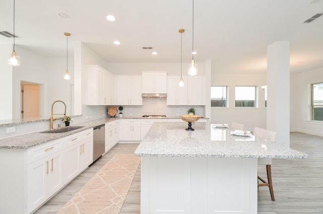 810 Sunbeam Creek Ct, Richmond, TX 77406 - kitchen with a sink, stainless steel appliances, light wood finished floors, decorative backsplash, and a peninsula