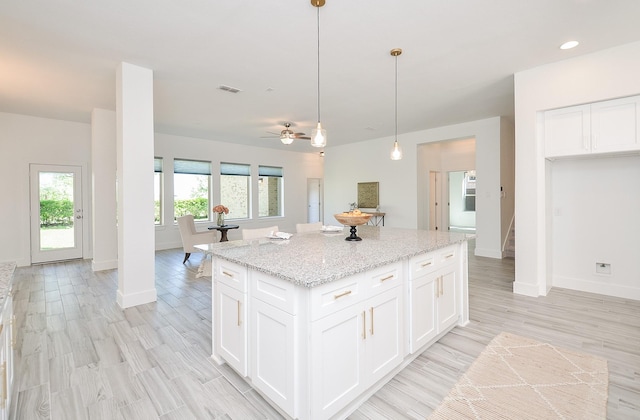 810 Sunbeam Creek Ct, Richmond, TX 77406 - kitchen with a kitchen island, baseboards, white cabinetry, light wood-type flooring, and recessed lighting
