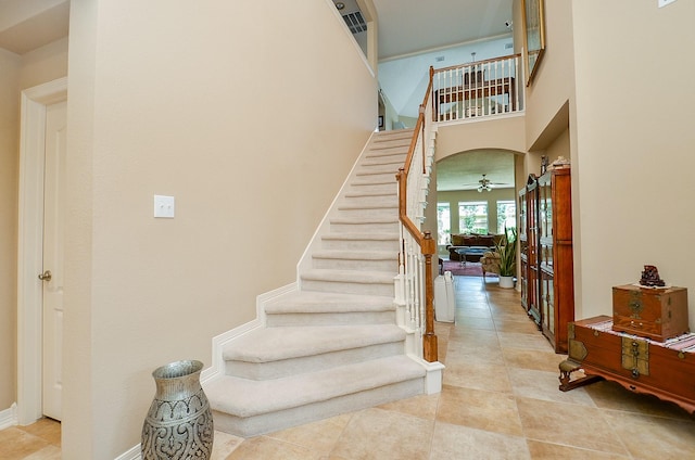 5703 Bent Arbor Ln, Katy, TX 77450 - stairway featuring tile patterned floors, ceiling fan, a high ceiling, and baseboards