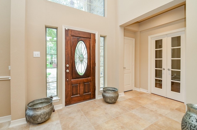 5703 Bent Arbor Ln, Katy, TX 77450 - entrance foyer with french doors, baseboards, light tile patterned flooring, and a towering ceiling