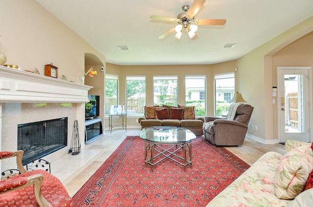 5703 Bent Arbor Ln, Katy, TX 77450 - living room with arched walkways, a high end fireplace, light tile patterned flooring, and a ceiling fan