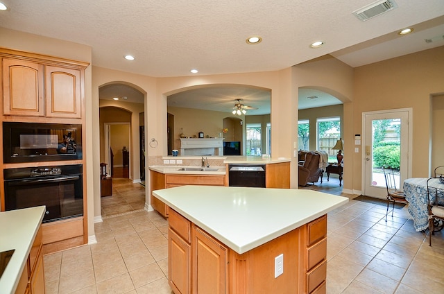 5703 Bent Arbor Ln, Katy, TX 77450 - kitchen with black appliances, open floor plan, a sink, arched walkways, and a kitchen island