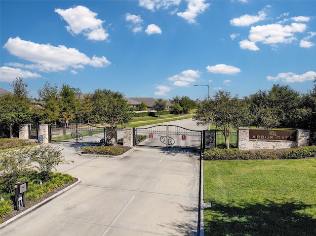 1417 Summer Field Ln, Friendswood, TX 77546 - view of concrete road featuring a gate, curbs, street lighting, and a gated entry