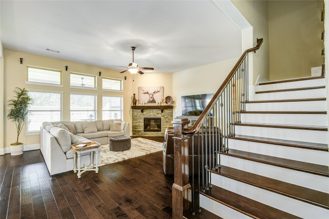 1417 Summer Field Ln, Friendswood, TX 77546 - living room with a ceiling fan, a stone fireplace, dark wood finished floors, stairs, and baseboards