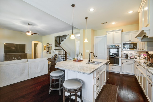 1417 Summer Field Ln, Friendswood, TX 77546 - kitchen with a sink, stainless steel appliances, dark wood-type flooring, light stone countertops, and a kitchen breakfast bar