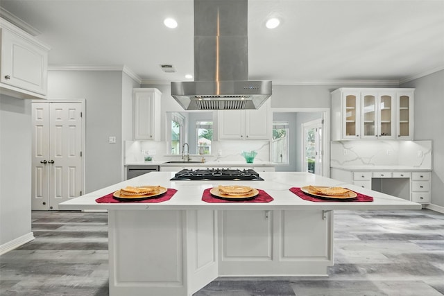2003 Birnam Wood Dr, Sugar Land, TX 77479 - kitchen with island range hood, ornamental molding, a sink, gas cooktop, and white cabinetry