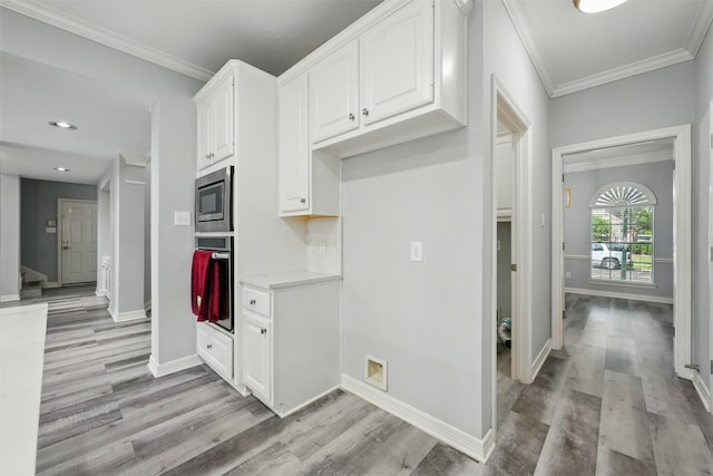 2003 Birnam Wood Dr, Sugar Land, TX 77479 - kitchen featuring stainless steel appliances, crown molding, light wood-type flooring, white cabinetry, and recessed lighting