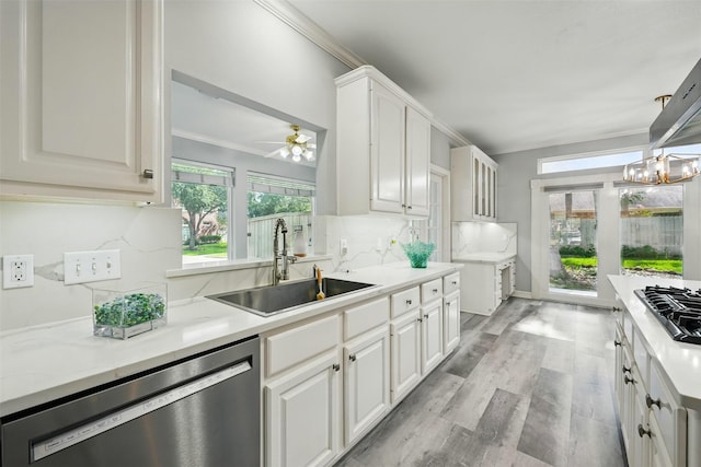 2003 Birnam Wood Dr, Sugar Land, TX 77479 - kitchen featuring appliances with stainless steel finishes, a sink, decorative backsplash, light countertops, and light wood finished floors