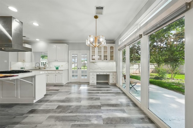 2003 Birnam Wood Dr, Sugar Land, TX 77479 - kitchen with island range hood, light countertops, a sink, white cabinets, and crown molding