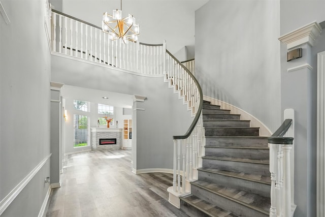 2003 Birnam Wood Dr, Sugar Land, TX 77479 - foyer featuring a high ceiling, stairway, wood finished floors, a glass covered fireplace, and a chandelier