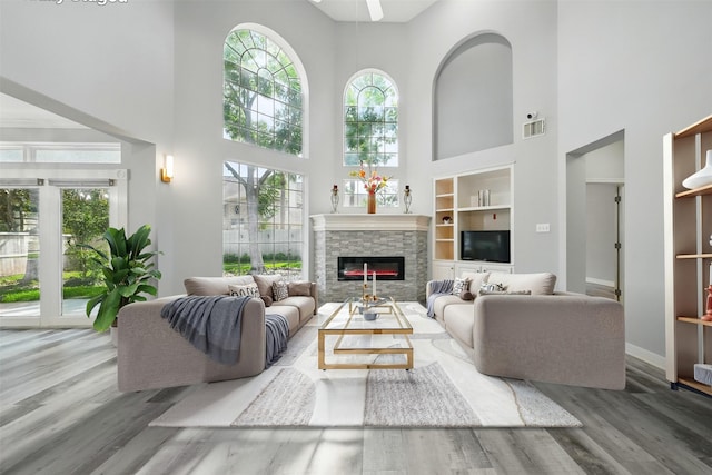 2003 Birnam Wood Dr, Sugar Land, TX 77479 - living room with a towering ceiling, wood finished floors, a fireplace, built in features, and baseboards
