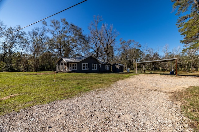 2175 Fm 1725th Rd, Cleveland, TX 77328 - view of front facade with driveway, a carport, a front lawn, and metal roof