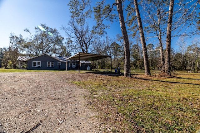 2175 Fm 1725th Rd, Cleveland, TX 77328 - view of front of home with driveway, a carport, metal roof, and a front lawn