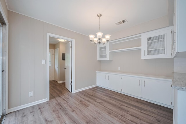 1316 Courtney St, Richmond, TX 77469 - unfurnished dining area with light wood-type flooring, a chandelier, and baseboards