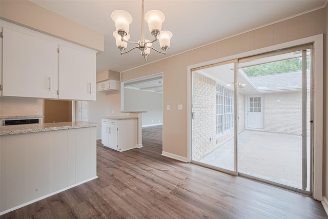 1316 Courtney St, Richmond, TX 77469 - kitchen with a chandelier, dark wood-style flooring, white cabinetry, baseboards, and light stone counters
