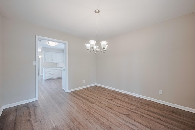 1316 Courtney St, Richmond, TX 77469 - spare room featuring a chandelier, wood finished floors, and baseboards