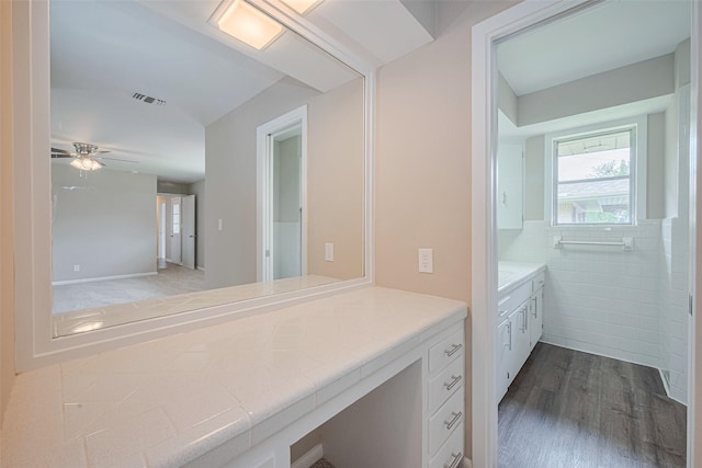 1316 Courtney St, Richmond, TX 77469 - bathroom featuring vanity, wood finished floors, ceiling fan, and tile walls