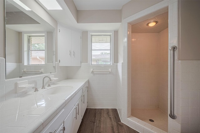 1316 Courtney St, Richmond, TX 77469 - full bathroom with vanity, wood finished floors, tile walls, and tiled shower