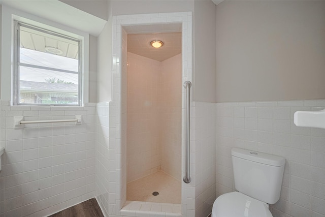 1316 Courtney St, Richmond, TX 77469 - bathroom with tile walls, toilet, a shower stall, and a wainscoted wall