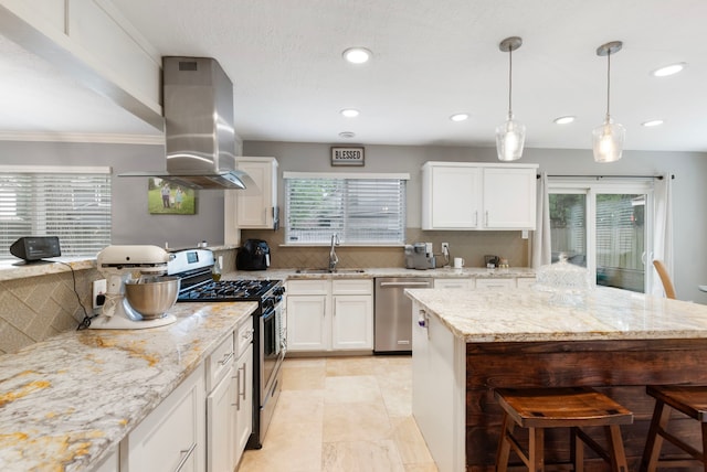 4 Hickory Oak Dr, Spring, TX 77381 - kitchen featuring appliances with stainless steel finishes, a sink, island range hood, a breakfast bar, and tasteful backsplash