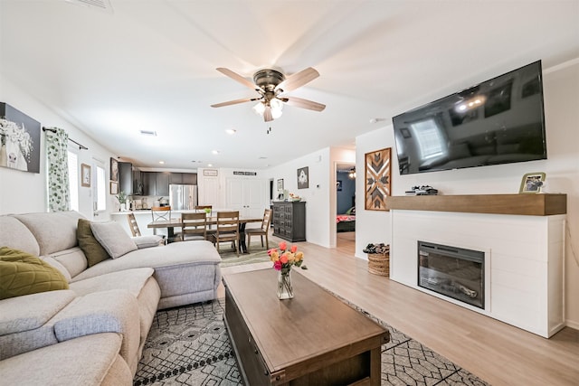 138 Austin Rd, Angleton, TX 77515 - living room with light wood-style flooring, ceiling fan, a glass covered fireplace, and recessed lighting