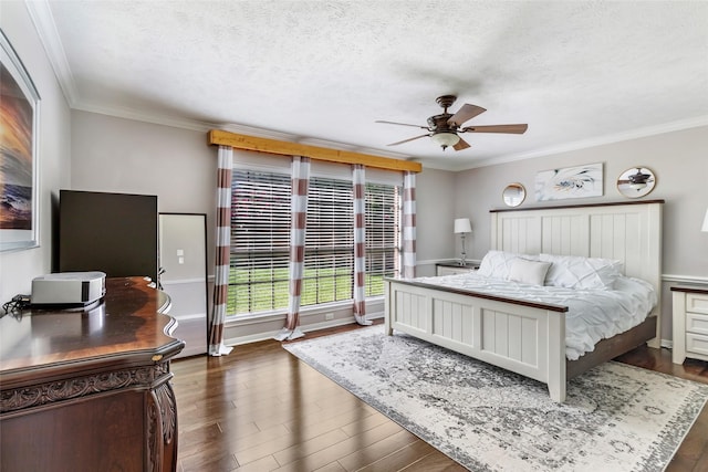 3911 Misty Gardens Ct, Kingwood, TX 77339 - bedroom featuring dark wood-style flooring, crown molding, a textured ceiling, ceiling fan, and baseboards