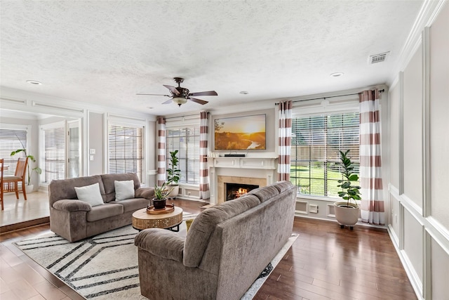 3911 Misty Gardens Ct, Kingwood, TX 77339 - living room featuring a textured ceiling, ceiling fan, dark wood finished floors, a lit fireplace, and recessed lighting