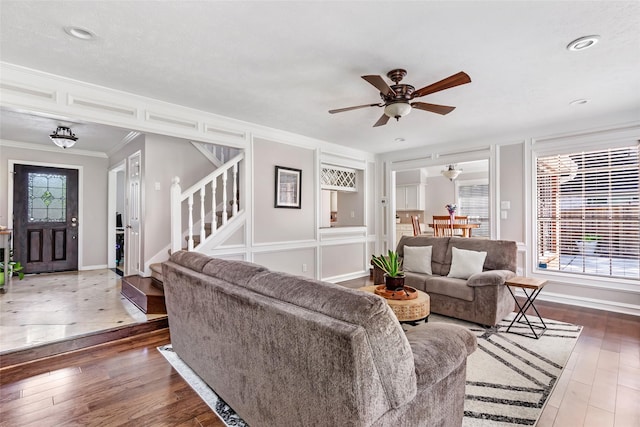3911 Misty Gardens Ct, Kingwood, TX 77339 - living area with ceiling fan, ornamental molding, stairs, wood-type flooring, and baseboards